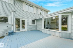 Expansive deck with light blue wood-finish flooring, a large bay window feature, and glass-paned double doors - 