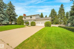 Two-story residence featuring light-colored siding, an attached garage, and a concrete driveway - 