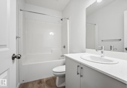 Bathroom featuring a white vanity with an integrated sink, chrome faucet, and mirrored backsplash - 