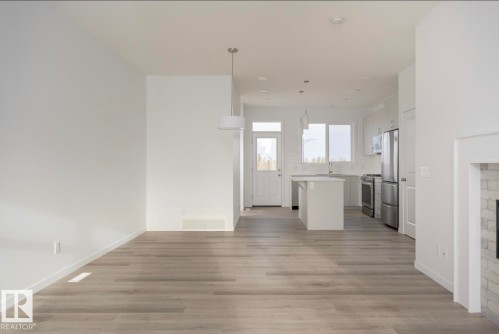 Open-concept living space featuring light wood-finish flooring and a neutral color palette - 3888 Wren Crescent, Edmonton, AB 