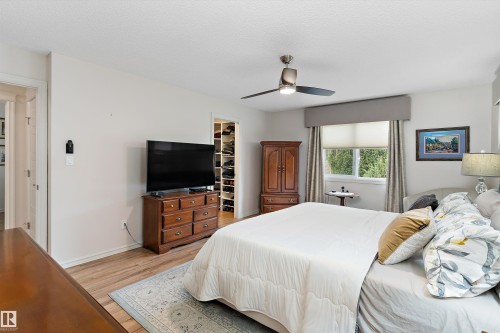 Bedroom featuring wood-finish flooring, a ceiling fan, and a window with blinds and drapery - 1097 Armitage Crescent, Edmonton, AB 