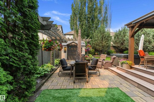 Expansive outdoor living area featuring a paver patio, composite deck with covered pergola, and a garden shed for storage - 1097 Armitage Crescent, Edmonton, AB 