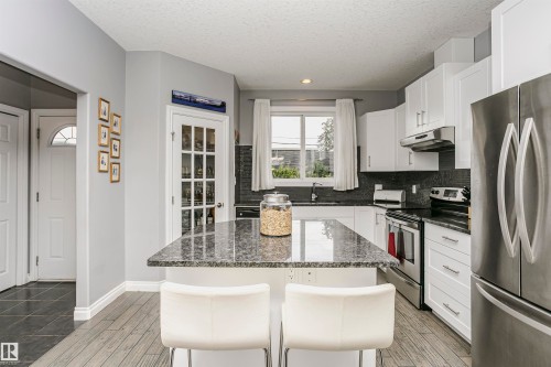 Kitchen with a central island featuring a stone countertop - 11619 125 Street, Edmonton, AB 