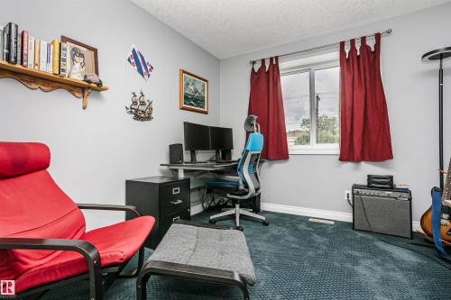 Bedroom presently used as office. Room featuring patterned blue carpeting and light gray walls - 11619 125 Street, Edmonton, AB 