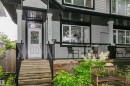 Exterior entrance featuring a white panel door with transom window, wooden stairs, and black handrails - 11619 125 Street, Edmonton, AB 