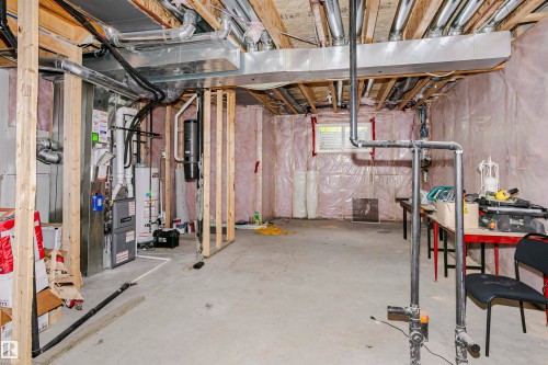 Unfinished basement featuring exposed wood framing, concrete flooring, and ceiling-mounted ductwork - 11619 125 Street, Edmonton, AB 
