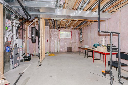Unfinished basement space featuring exposed wooden joists, concrete flooring, and insulated walls - 11619 125 Street, Edmonton, AB 