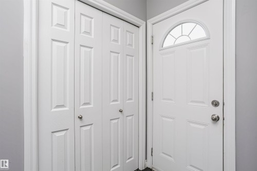 Entry area featuring a paneled door with an arched transom window and bifold closet doors - 11619 125 Street, Edmonton, AB 