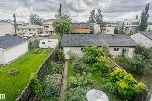 Expansive backyard featuring a lush lawn, established garden beds, and mature trees - 11619 125 Street, Edmonton, AB 