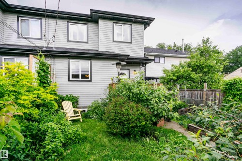 Rear exterior of the property featuring light gray horizontal siding and a dark roofline - 11619 125 Street, Edmonton, AB 