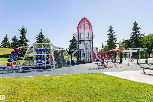 Neighbourhood expansive outdoor playground featuring a rocket-themed structure, climbing apparatus, swings, and a spring rider - 11619 125 Street, Edmonton, AB 