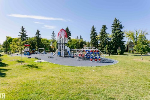 Expansive outdoor park space featuring multiple play structures, including a rocket-themed climbing frame, slides, swings, and a geometric climbing dome - 11619 125 Street, Edmonton, AB 