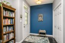 Entryway featuring dark tile flooring, a white paneled door with decorative glass, and a transom window - 11619 125 Street, Edmonton, AB 