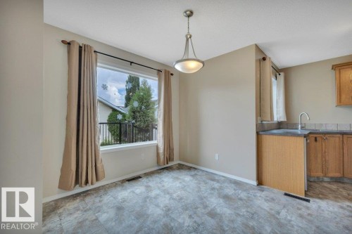 Spacious dining room looking over the back deck and yard - 7948 13 Avenue, Edmonton, AB 