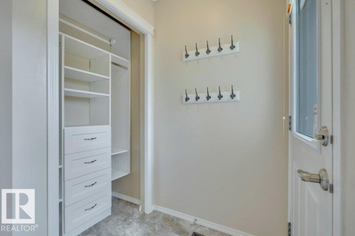 Back entry - step in off the back deck to this spacious entry complete with coat hooks and a closet organizer - 7948 13 Avenue, Edmonton, AB 