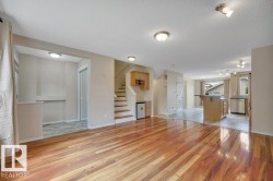 Beautiful and spacious living room accented with Tigerwood hardwood, gas fireplace, and built in entertainment niches with a built in bar area with extra cabinets. - 