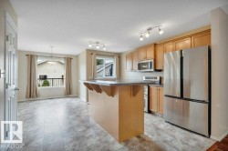 Spacious kitchen includes upgraded appliances and a raised eating bar plus a pantry. - 