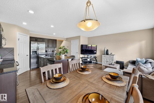 Open-concept living space with wood-finish flooring, recessed lighting, and a neutral wall color - 12119 167A Avenue, Edmonton, AB 
