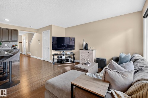 Open-concept living space with wood-finish flooring, a neutral wall palette, and recessed ceiling lighting - 12119 167A Avenue, Edmonton, AB 