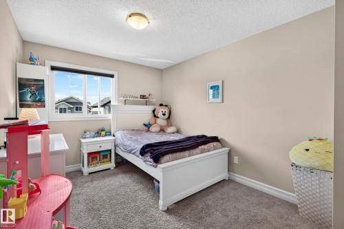 Carpeted room featuring a double-pane window, neutral wall paint, and white trim - 12119 167A Avenue, Edmonton, AB 