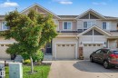 Two-story townhome with light-colored siding and a dark brown front door - 12119 167A Avenue, Edmonton, AB 