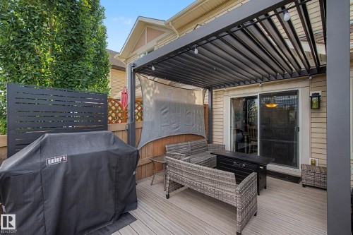 Outdoor deck featuring a louvered pergola with string lights, privacy screen, and sliding glass door access to the interior - 12119 167A Avenue, Edmonton, AB 