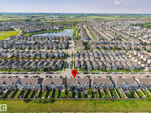 Aerial perspective of a residential community featuring a prominent central pond - 12119 167A Avenue, Edmonton, AB 