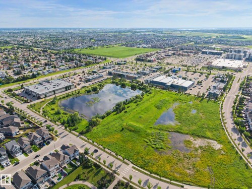 Aerial perspective showcasing a developed neighborhood with diverse architectural styles, commercial buildings, and extensive green spaces - 12119 167A Avenue, Edmonton, AB 