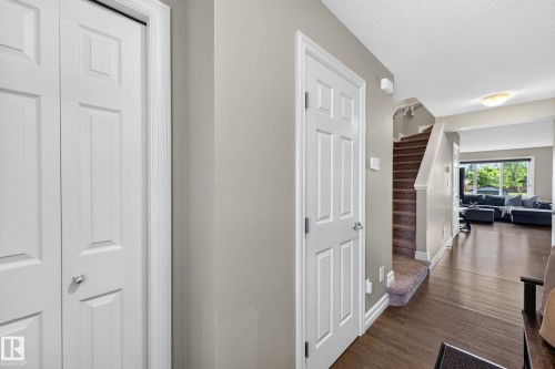 Entryway with white paneled doors, neutral wall paint, and dark wood-finish flooring - 12119 167A Avenue, Edmonton, AB 