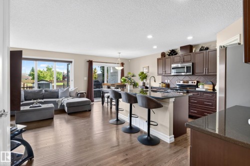 Open-concept living area featuring rich wood-finish flooring throughout - 12119 167A Avenue, Edmonton, AB 