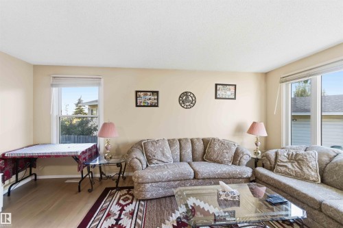 Bright living area with light-toned walls and wood-finish flooring - 8819 29 Avenue, Edmonton, AB 