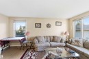 Bright living area with light-toned walls and wood-finish flooring - 8819 29 Avenue, Edmonton, AB 