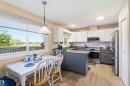 Kitchen featuring light wood-finish flooring and a U-shaped island with a breakfast bar - 8819 29 Avenue, Edmonton, AB 
