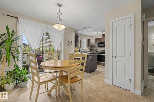 Dining area featuring tile flooring, a glass sliding door to a balcony, and a contemporary pendant light fixture - 25 12004 22 Avenue, Edmonton, AB - Indoor Photo Showing Dining Room