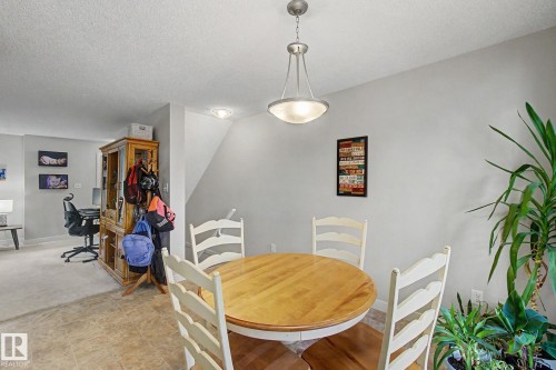 Dining area featuring a contemporary pendant light fixture, tile flooring, and a neutral wall color - 25 12004 22 Avenue, Edmonton, AB - Indoor Photo Showing Dining Room