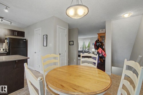 Bright dining area featuring a light wood-finish table, tile flooring, and a contemporary ceiling fixture - 25 12004 22 Avenue, Edmonton, AB - Indoor Photo Showing Dining Room