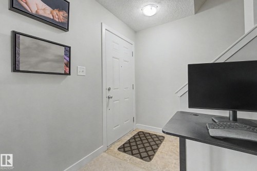 Entryway featuring a paneled door, flush-mount ceiling light, and light-toned tile flooring - 25 12004 22 Avenue, Edmonton, AB - Indoor Photo Showing Other Room