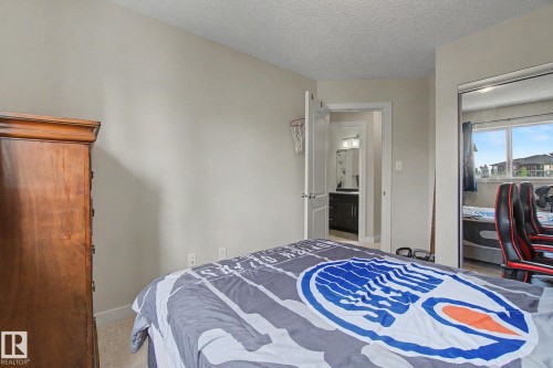 Carpeted bedroom with neutral wall tones and a mirrored closet - 25 12004 22 Avenue, Edmonton, AB - Indoor Photo Showing Bedroom