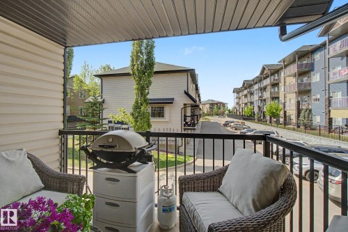 Private balcony featuring horizontal vinyl siding, a black metal railing, and a slatted ceiling - 25 12004 22 Avenue, Edmonton, AB - Outdoor With Balcony With Exterior