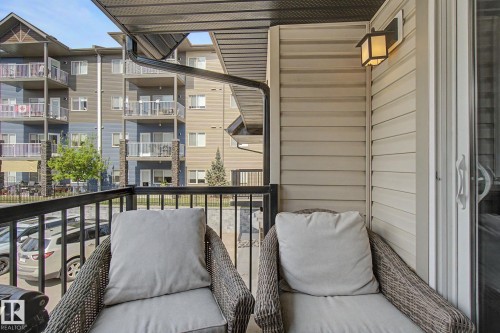 Private balcony featuring a black metal railing and tan siding - 25 12004 22 Avenue, Edmonton, AB - Outdoor With Balcony With Exterior