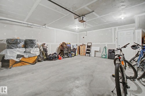 Spacious garage featuring a concrete floor, unpainted drywall, and an interior access door - 25 12004 22 Avenue, Edmonton, AB - Indoor Photo Showing Garage