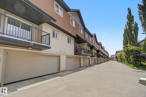 Townhouse exterior featuring dual-tone siding, a private balcony with black railings, and an integrated garage - 25 12004 22 Avenue, Edmonton, AB - Outdoor With Balcony With Exterior