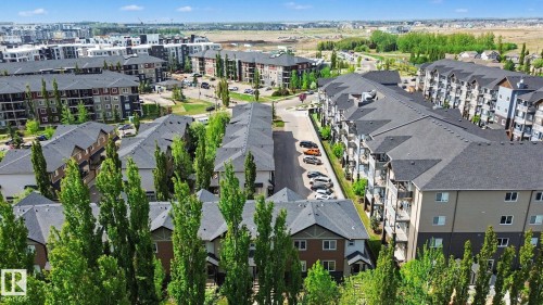 Aerial perspective showcasing a residential community with multi-story buildings and townhome-style residences - 25 12004 22 Avenue, Edmonton, AB - Outdoor With View