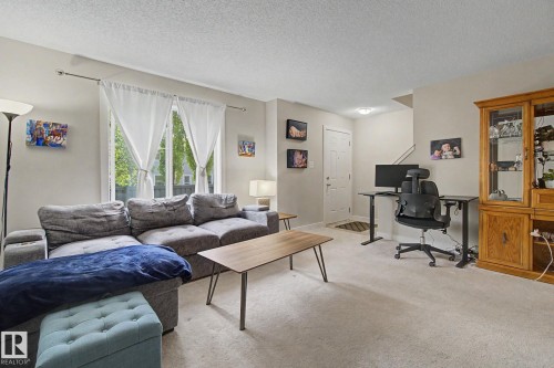 Living space featuring light-toned carpeting and a neutral wall color - 25 12004 22 Avenue, Edmonton, AB - Indoor Photo Showing Living Room