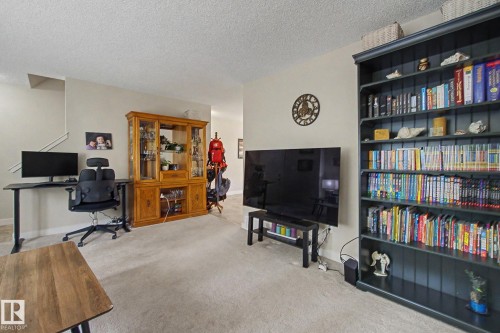 Carpeted flooring enhances this living area with neutral wall tones - 25 12004 22 Avenue, Edmonton, AB - Indoor Photo Showing Other Room