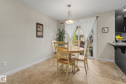 Dining area featuring light-toned walls and tile-finish flooring - 25 12004 22 Avenue, Edmonton, AB - Indoor Photo Showing Dining Room