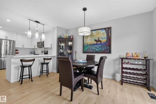 Open-concept kitchen and dining area featuring light wood-finish flooring - 5129 Lark Crescent, Edmonton, AB 