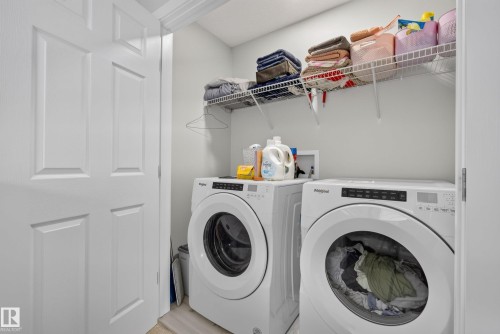 Dedicated laundry area featuring front-loading appliances, overhead wire shelving, and white paneled doors - 5129 Lark Crescent, Edmonton, AB 