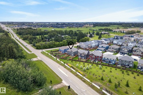 Aerial perspective showcasing a residential development bordering open green spaces and a multi-lane roadway - 5129 Lark Crescent, Edmonton, AB 