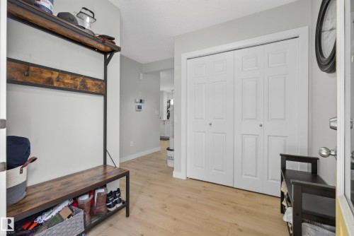 Entryway featuring light wood-finish flooring, white bifold closet doors, and light gray wall paint - 5129 Lark Crescent, Edmonton, AB 